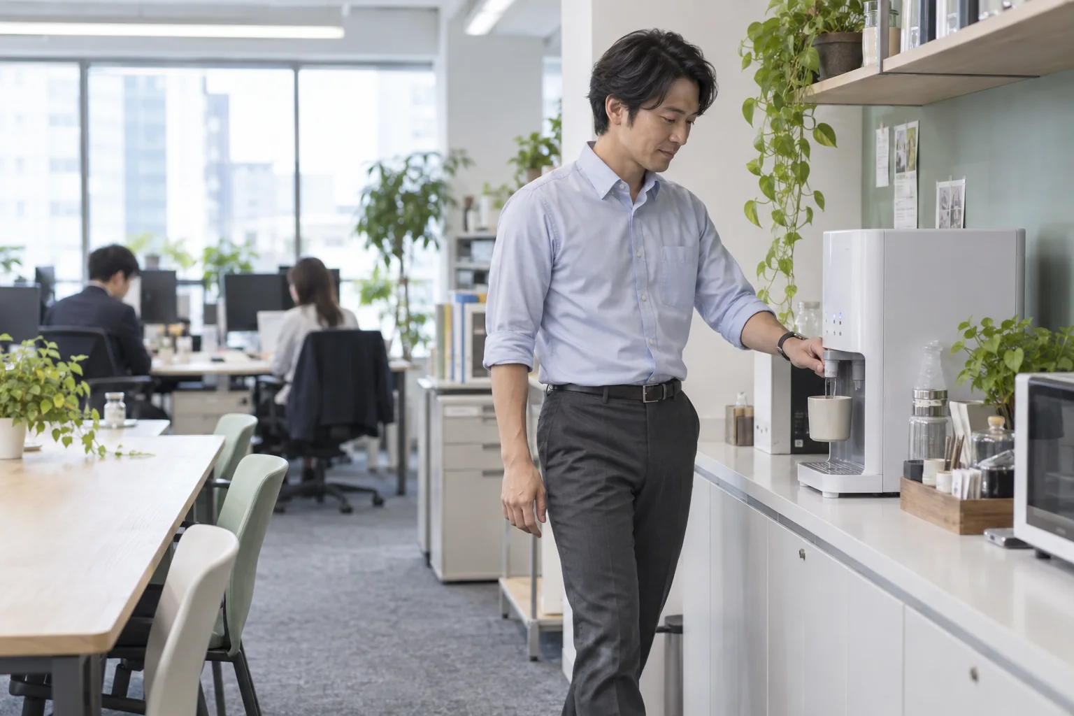 オフィスの給水スペースまで歩いて飲み物を用意する様子